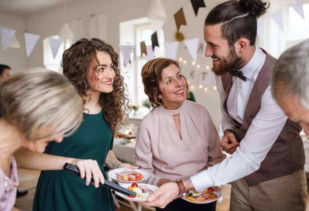 party host serving food to party guests at and indoor party