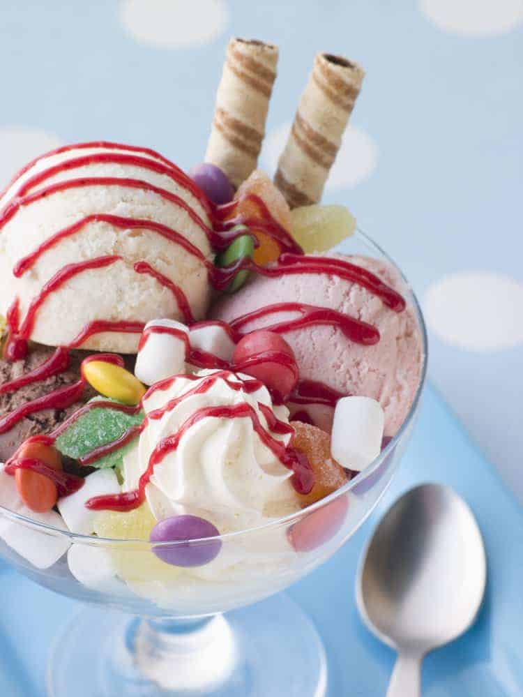 Ice cream sundae in glass cup with lots of toppings