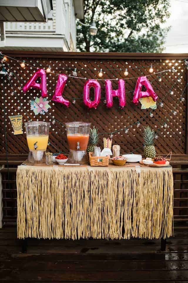 luau party table with aloha balloons in background