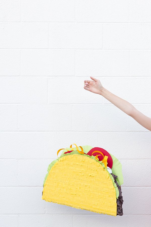 DIY Taco pinata being held by an outstretched arm