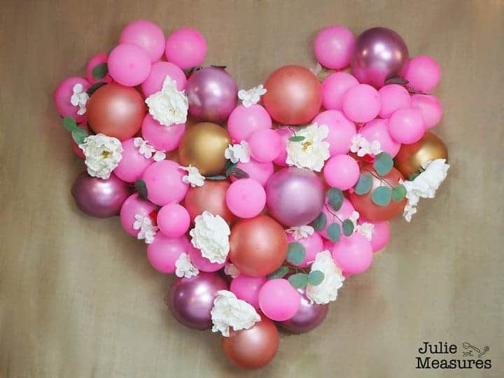 DIY balloon backdrop in a shape of a heart with flowers