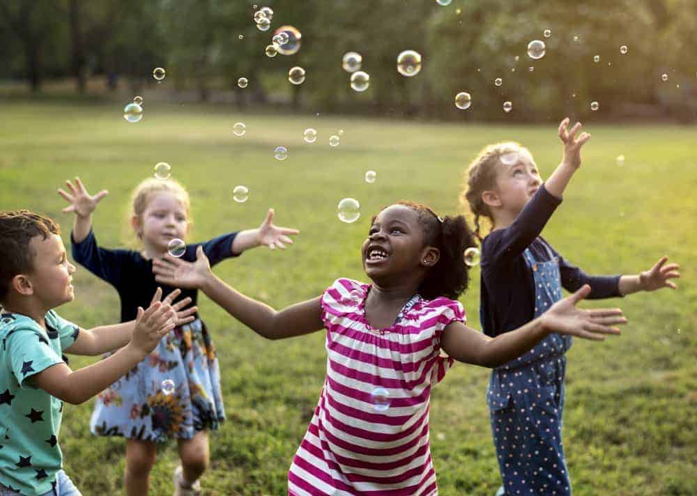 children playing with bubbles in the park