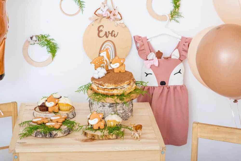 birthday party table setup with swee deer and woodland decor, treats, cookies and a deer dress