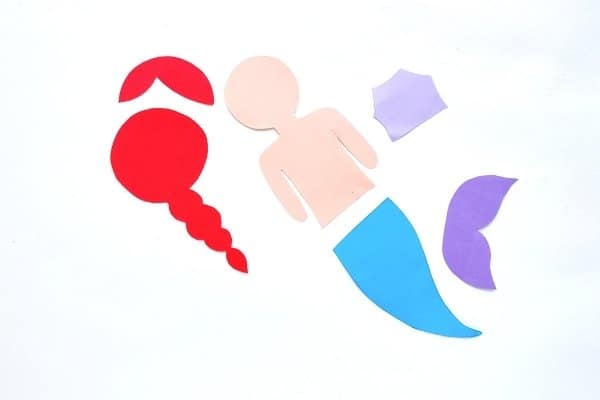 pieces of construction paper cut out from a printable mermaid template on white background