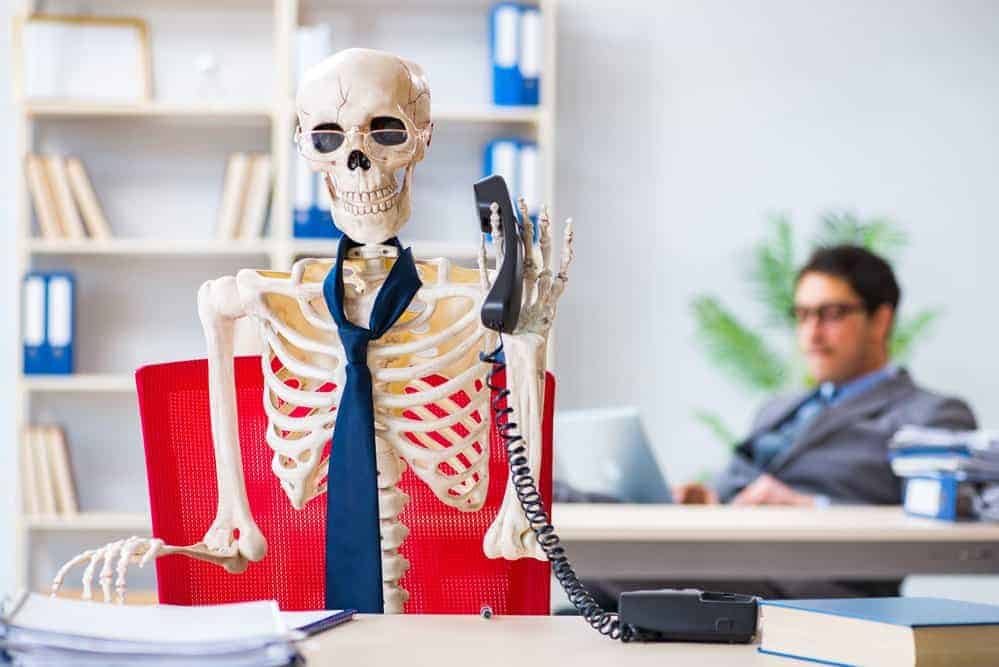 Businessman working with skeleton in office