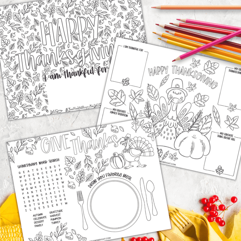 trio of printable thanksgiving placemats on a fall flat lay with colored pencils