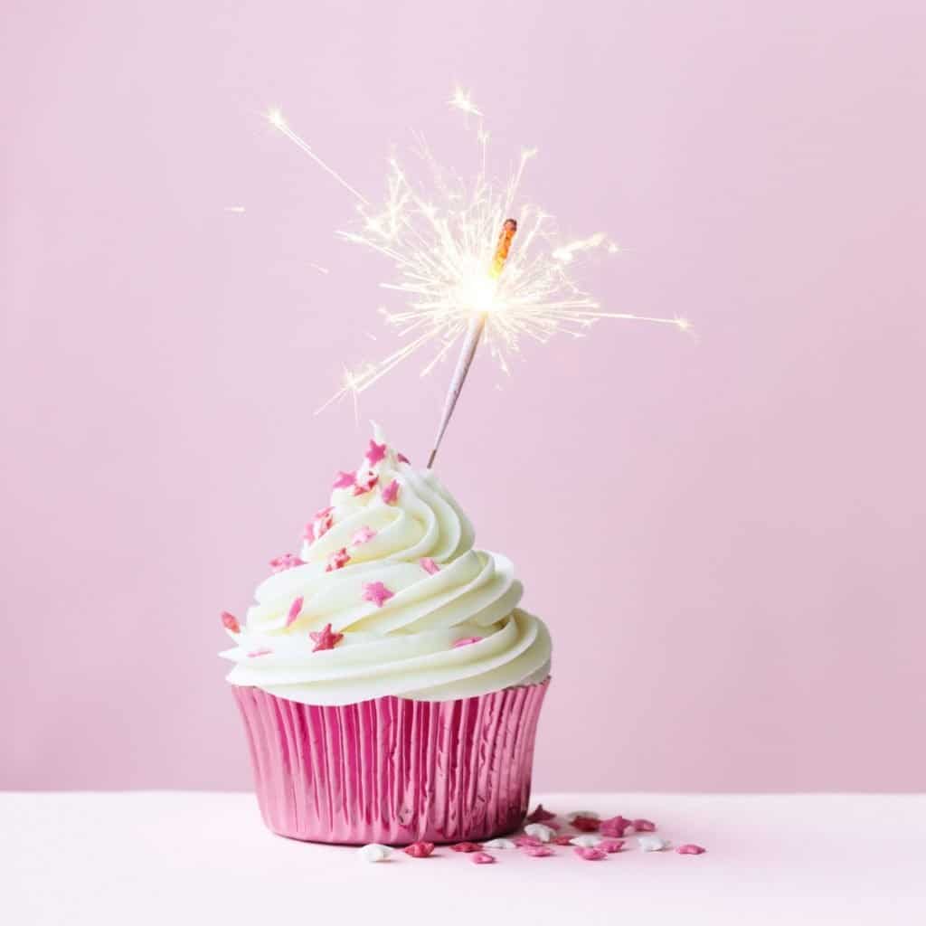 purple and white cupcake with sparkler with purple background