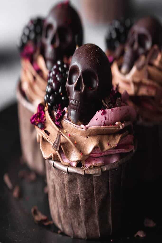 blackberry skull cupcakes with chocolate skull on top of frosting