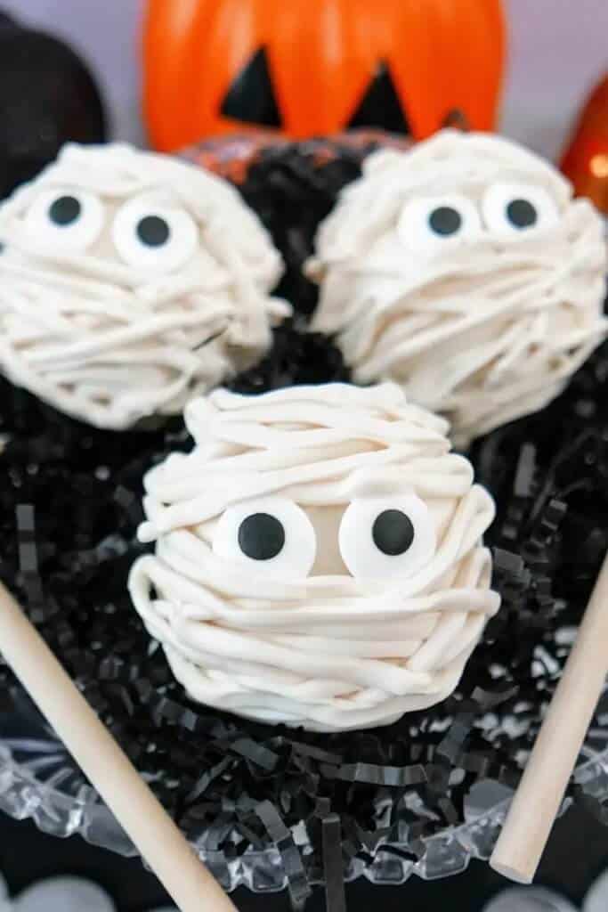 candy bombs decorated like mummies with candy eyes and swirled white chocolate
