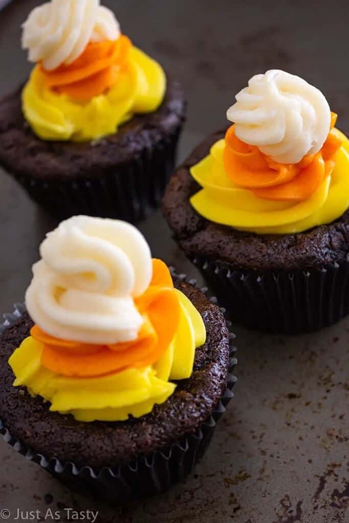 chocolate cupcakes with layered frosting making them appear to be candy corn cupcakes