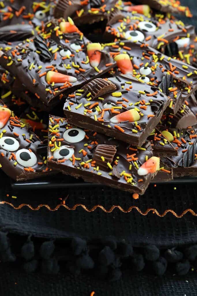 yummy halloween bark candy made out of chocoalte, candy corn, reeses mini cups and sprinkles