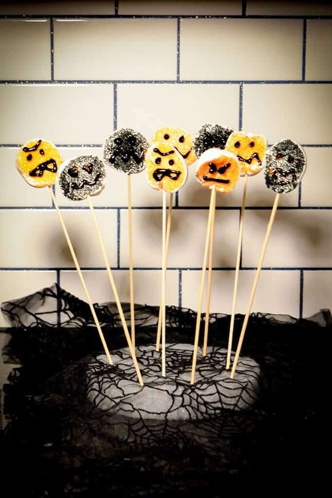 monster marshmallow pops standing in a halloween dessert display