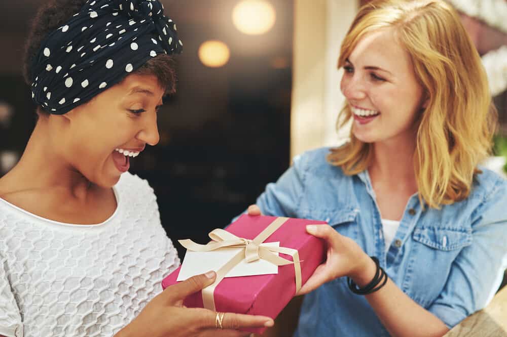 woman giving another woman a a luxury gift