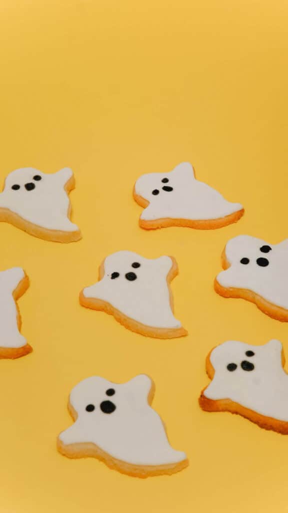 halloween wallpaper background image consisting of white ghost sugar cookies on a yellow background