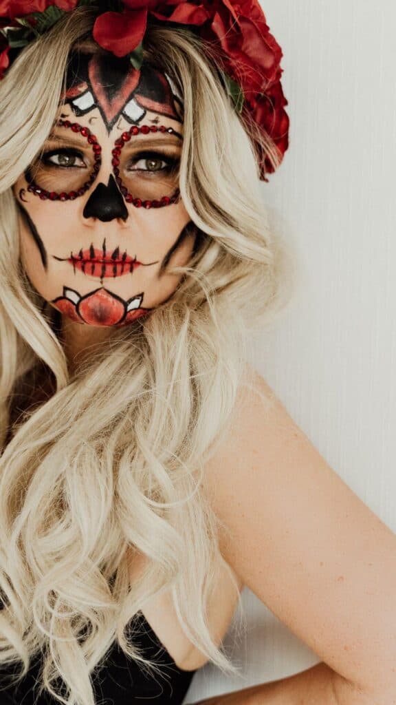 halloween wallpaper background image consisting of closeup of blonde woman wearing dios de los muertos face paint and rose crown