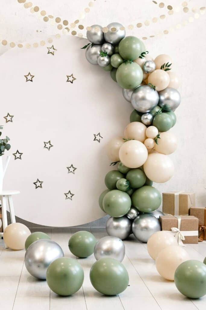 olive green, tan and silver balloon garland on a round starry backdrop