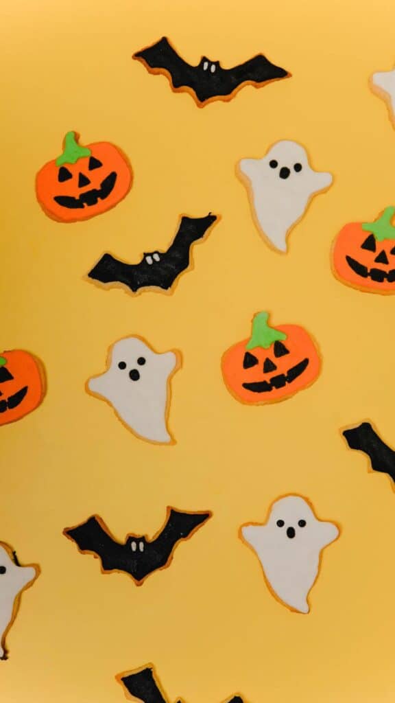halloween wallpaper background image consisting of halloween sugar cookies on yellow backdrop