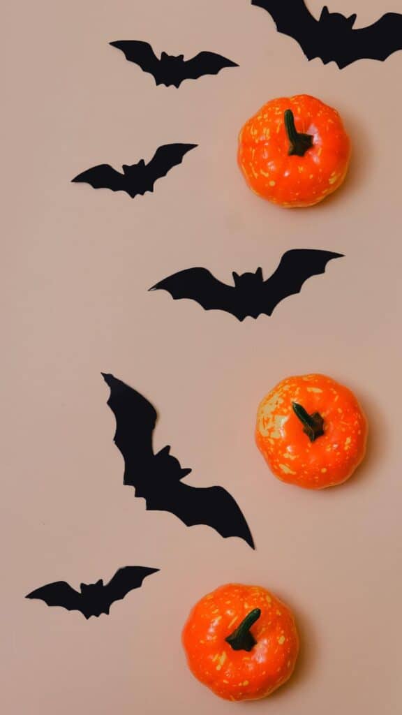 halloween wallpaper background image consisting of black paper bats and plastic mini pumpkins